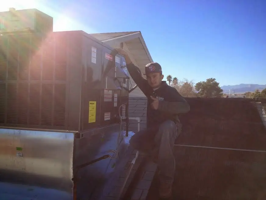 HVAC technician performing AC Tune-Up on a rooftop unit in Mercer Island